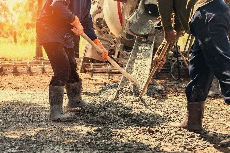 pouring_concrete_with_worker_mix_cement_at_construction_site