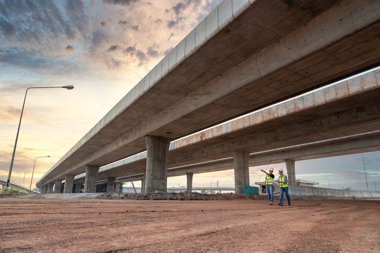 Asian_civil_engineers_and_foremen_walking_to_inspect_a_road_or_expressway_construction_project_under_a_road_under_construction.