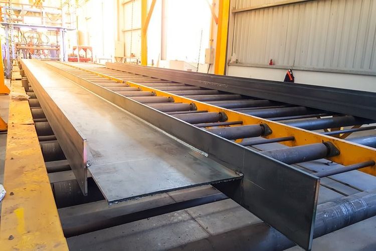 steel_fabrication_process_with_metal_beams_on_a_conveyor_system