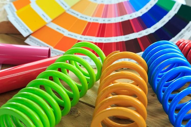 colourful_powder_coated_springs_and_paint_swatches_on_wooden_surface