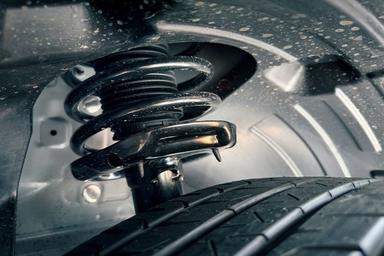 closeup_of_car_suspension_spring_and_tire_in_dirty_conditions