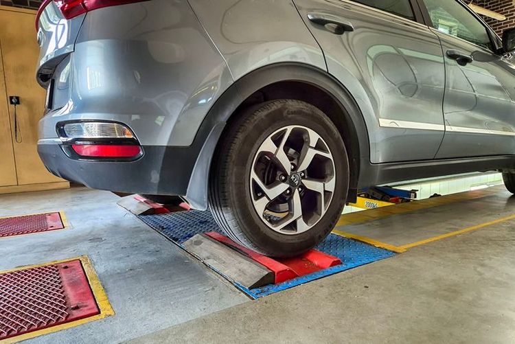 silver_suv_on_vehicle_testing_ramp_in_workshop