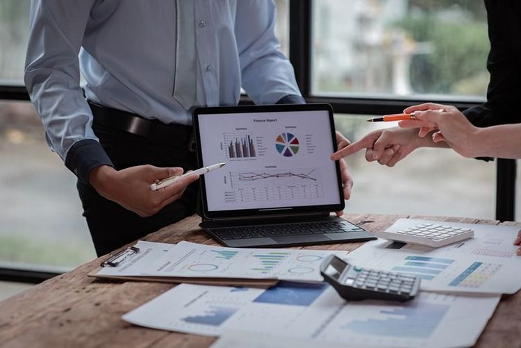 group_discussing_financial_graphs_on_a_laptop_at_a_meeting
