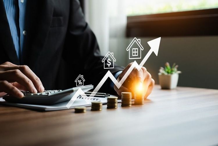 businessman_calculating_with_stacked_coins_and_graph_icons_representing_growth