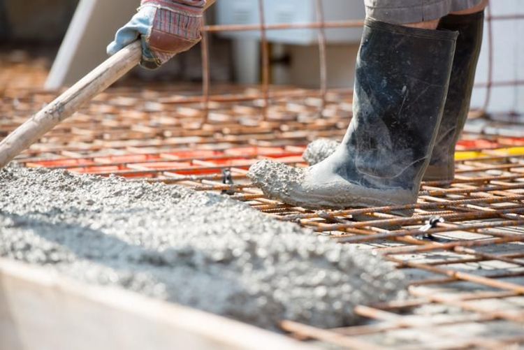 Worker_pouring_concrete_mix_at_home_foundation