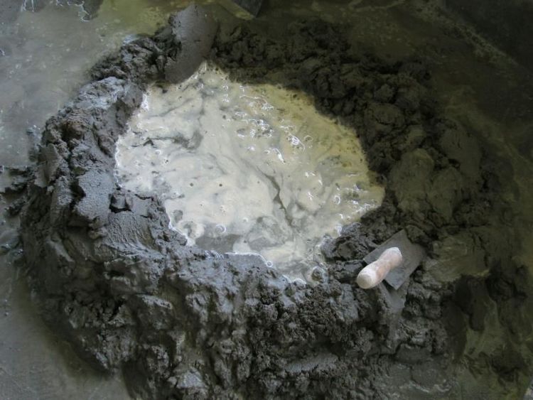 Mixed_cement.Water_reacts_with_cement_in_a_chemical_process_known_as_mineral_drying.