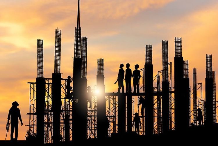 silhouette_of_construction_workers_with_steel_frames_at_sunset