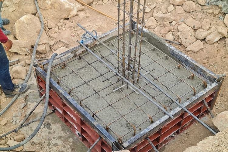 Concrete_in_steel_form_poured_concrete_in_the_building_construction_area_on_the_mountain._The_red_shirt_workers_were_smoothing_their_faces_with_a_wooden_block.