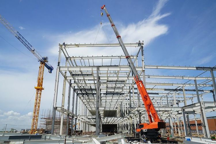 large_peb_structure_under_construction_with_steel_columns_and_cranes_on_site