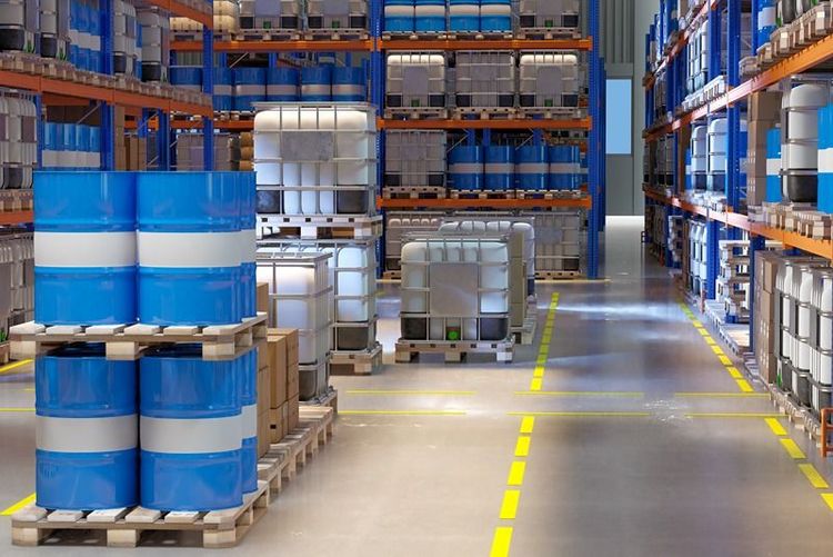 Industrial_warehouse_with_steel_racks_holding_large_blue_drums_and_white_containers_showcasing_a_robust_racking_solution.