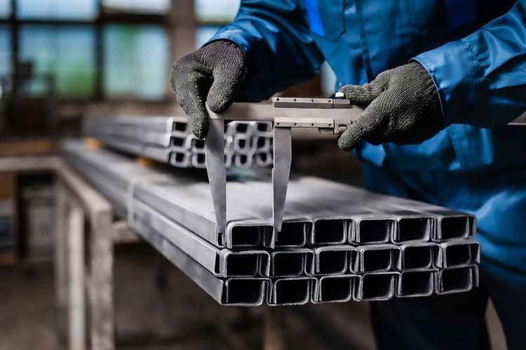 A_welder_is_welding_steel_on_a_steel_roof_truss._Working_at_height_equipment._Fall_arrestor_device_for_worker_with_hooks_for_safety_body_harness._Worker_in_construction_site.