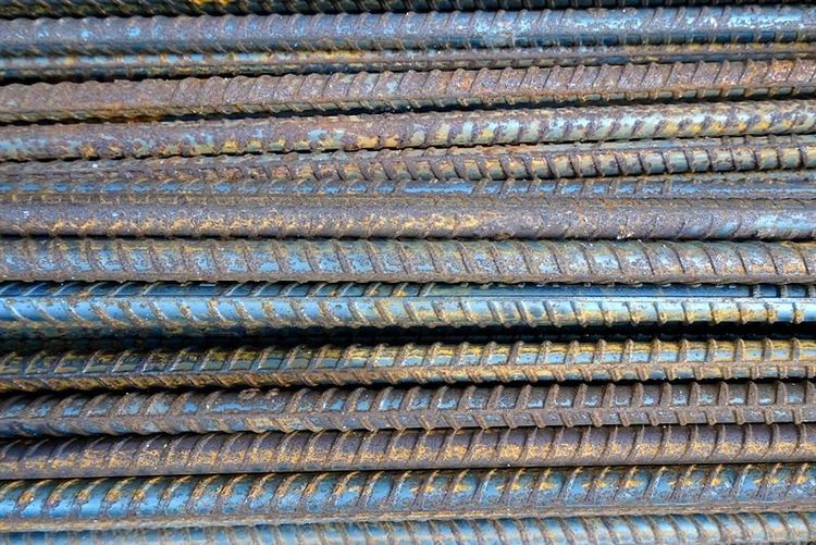 closeup_view_of_tmt_bars_arranged_on_soil_surface_highlighting_uniform_ribs